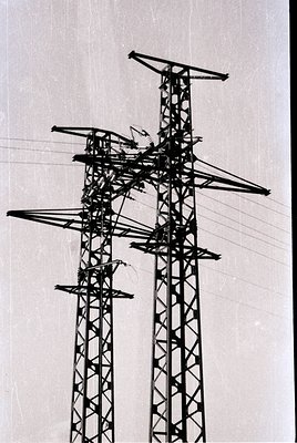 High-voltage transmission tower with lattice steel framework and cross-arms supporting overhead power lines, likely from mid-...