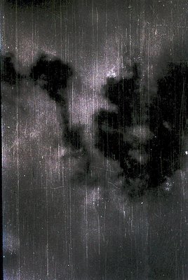 Vintage monochrome photograph of a **silhouetted couple embracing** in heavy rain, captured through a **vertical rain-streake...