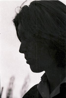 Silhouetted profile of a person in mid-speech, likely mid-20th century based on hairstyle and clothing. Dark, structured jack...