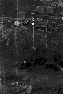 Aerial view of a mid-20th-century industrial site, likely a coal or ore mine. Visible: wooden crates, conveyor belts, and a c...