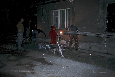 Nighttime repair crew repairs damaged concrete sidewalk using floodlights and hand tools. Damaged concrete slab and metal bar...