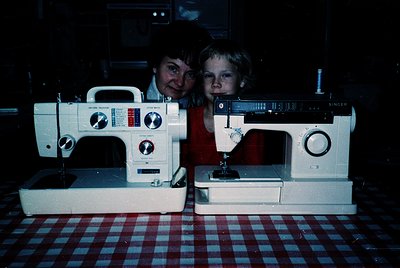 Vintage sewing machines—one **Singer** and one **Brother**—displayed on a checkered tablecloth, likely from the **1970s–1980s...