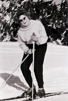 Classic black-and-white ski portrait from the 1960s–70s, featuring a person in classic cross-country ski attire: long-sleeve ...