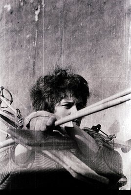 Close-up of a person playing a vintage rifle-style toy gun, likely a cap gun or BB gun, indoors. The individual appears to be...