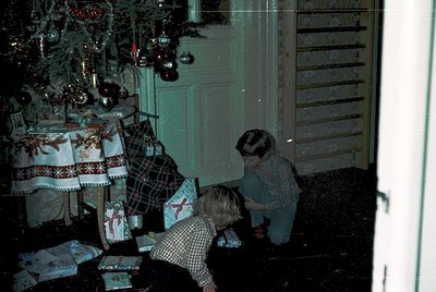 Vintage indoor holiday scene featuring three children opening wrapped gifts under a decorated Christmas tree. Tablecloth with...
