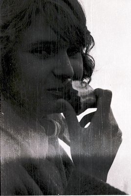 Black-and-white portrait of a person in contemplative pose, hand resting on chin. Soft, diffused lighting suggests vintage fi...