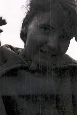 Black-and-white portrait of a person laughing, captured through rain-streaked glass. The vintage filter and blurred backgroun...