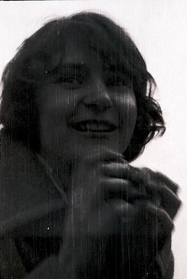 Black-and-white portrait of a person laughing under a shower, water droplets forming a natural frame. Mid-century styling wit...