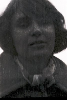 Portrait of an individual in a vintage-style black-and-white photo, likely from the 1940s–1960s. The subject wears a dark, hi...