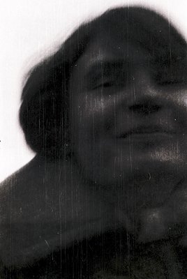 Silhouetted portrait of a person with short hair, captured mid-rain under a vertical light source. The water droplets create ...