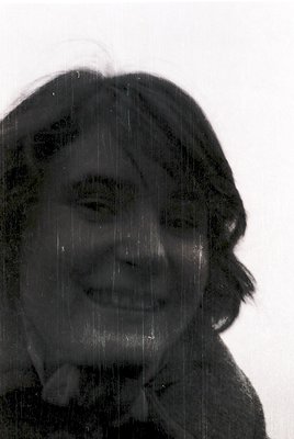 Portrait of a person smiling through rain-streaked glass, creating a blurred, artistic effect. The monochrome tone and water ...