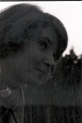 Silhouetted portrait of a person standing in rain, blurred by falling water droplets. Classic monochrome aesthetic with high-...