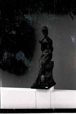 Modernist bronze sculpture of a seated female figure in abstract, flowing drapery. Minimalist pedestal with subtle text. Dark...