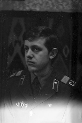 A black and white portrait of a man in a military uniform. He wears shoulder boards with the letters 'CA' and a small emblem,...