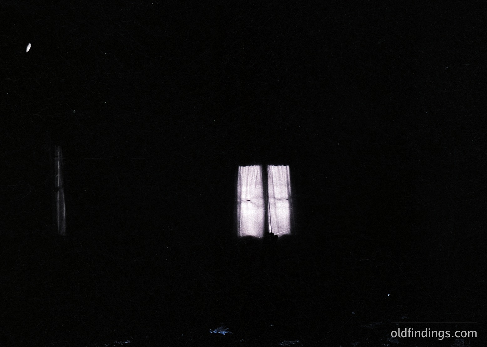 Minimalist black-and-white nighttime shot of two vertical light streaks against a dark sky, resembling abstract geometric shapes or early film grain. Likely experimental or artistic photography from the 20th century.