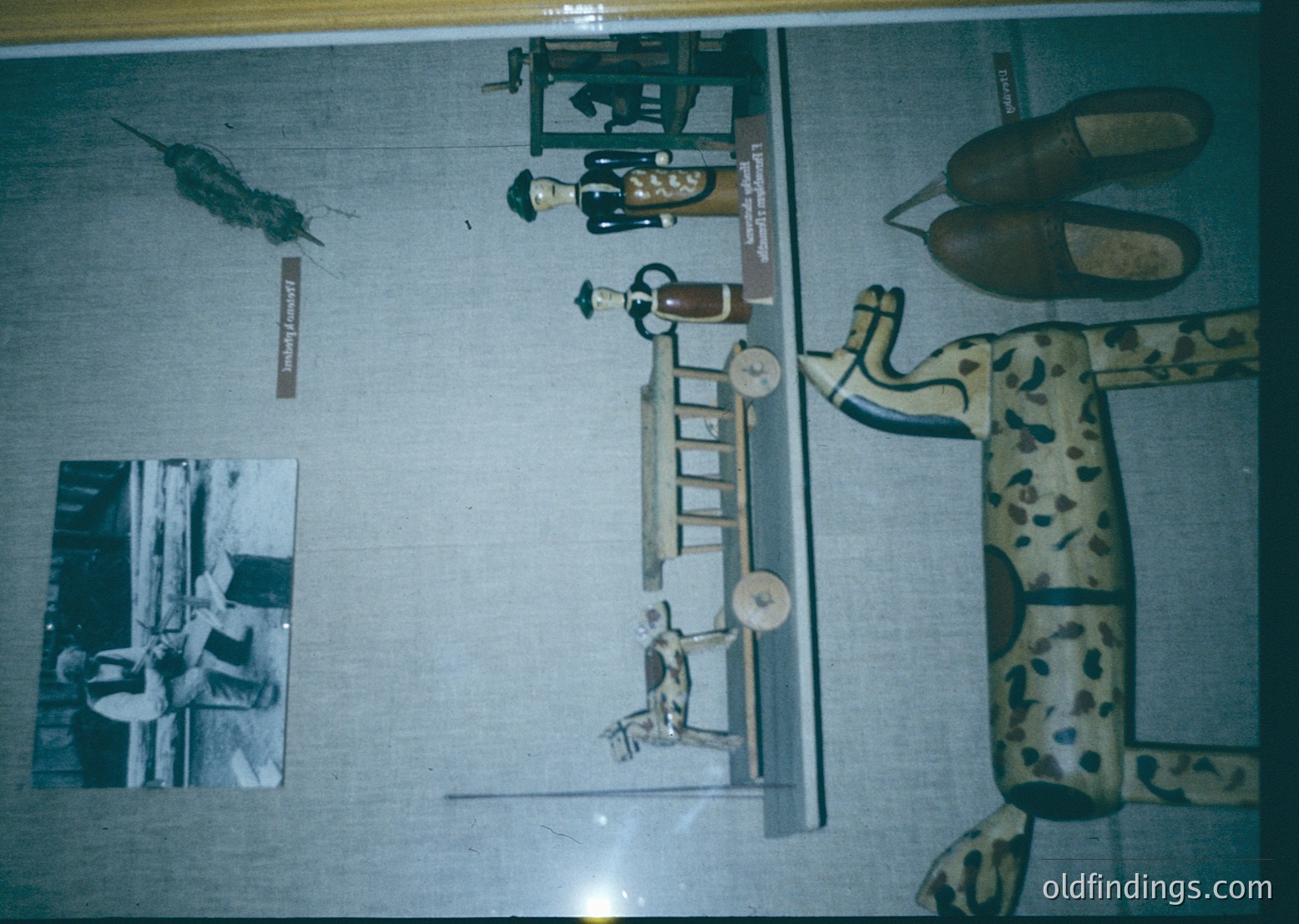 Vintage medical training mannequin with articulated limbs, ladder, and medical tools displayed on a light blue backdrop. Black-and-white inset photo shows a seated patient with a medical professional. Likely from a 1950s–1970s medical training facility.