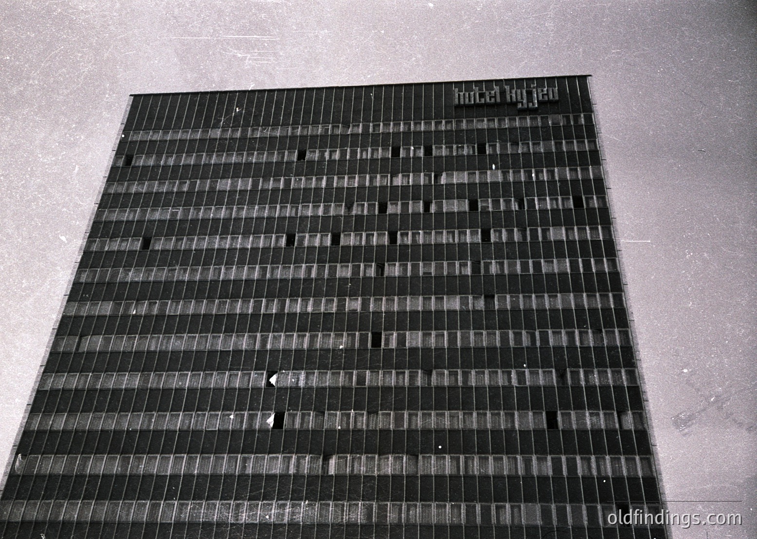 Mid-century Brutalist concrete panel wall with grid-like texture, likely part of institutional or public architecture. The rough, exposed aggregate finish suggests 1960s–1980s construction. Possible use in schools, government buildings, or housing projects.