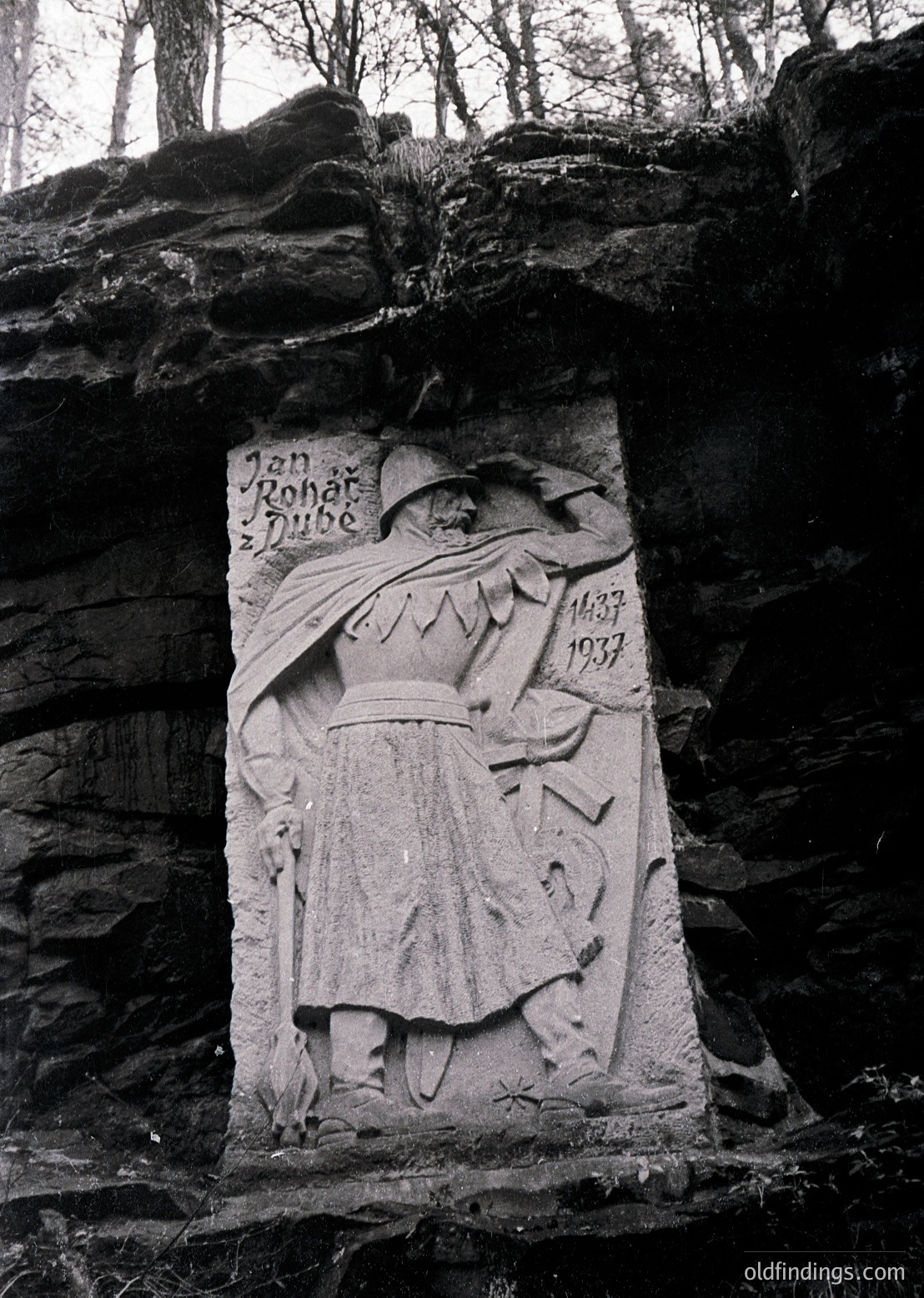 Relief sculpture of a robed figure holding a staff, carved into a rocky cliff face. Engraved inscription reads *"Jan Roháč z Dubé 1537"* with dates marking his life (1488–1537). Historic Czech military leader memorialized in outdoor setting.