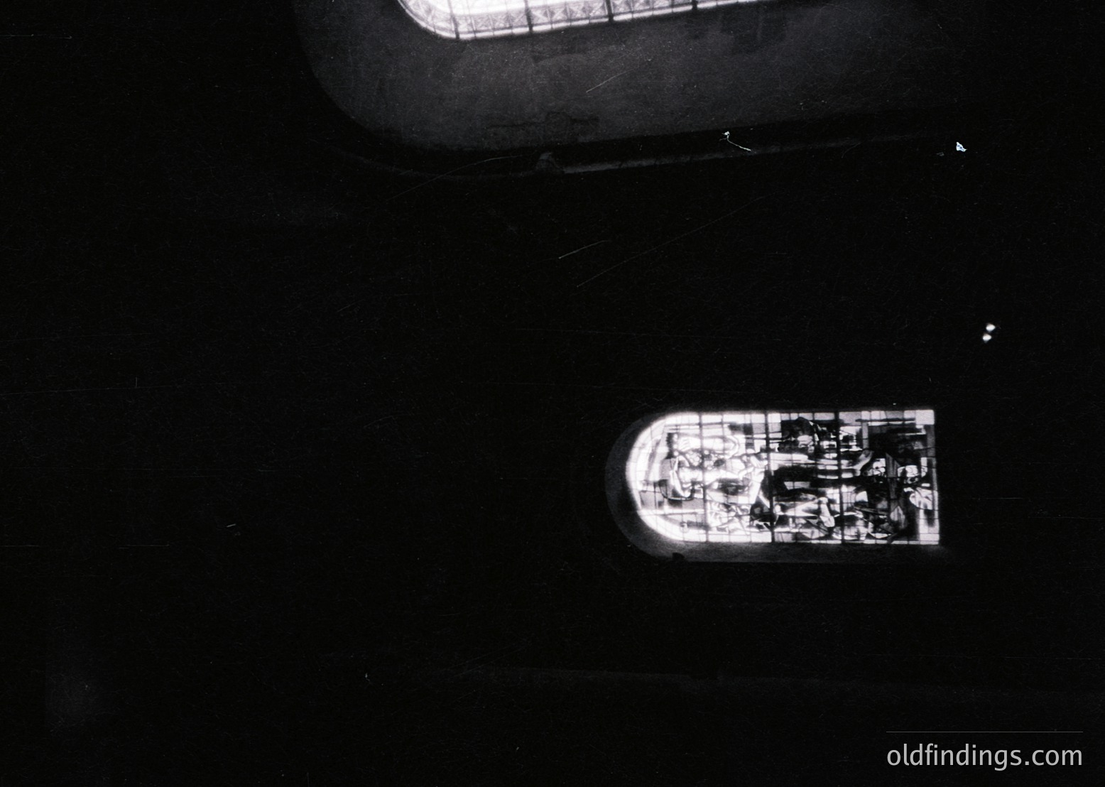 Aerial view of a small, dark-toned vessel with visible deck structures and a single mast, likely a sailboat or small yacht. The image appears low-light or nighttime, emphasizing silhouettes. Potential maritime or nautical research value.