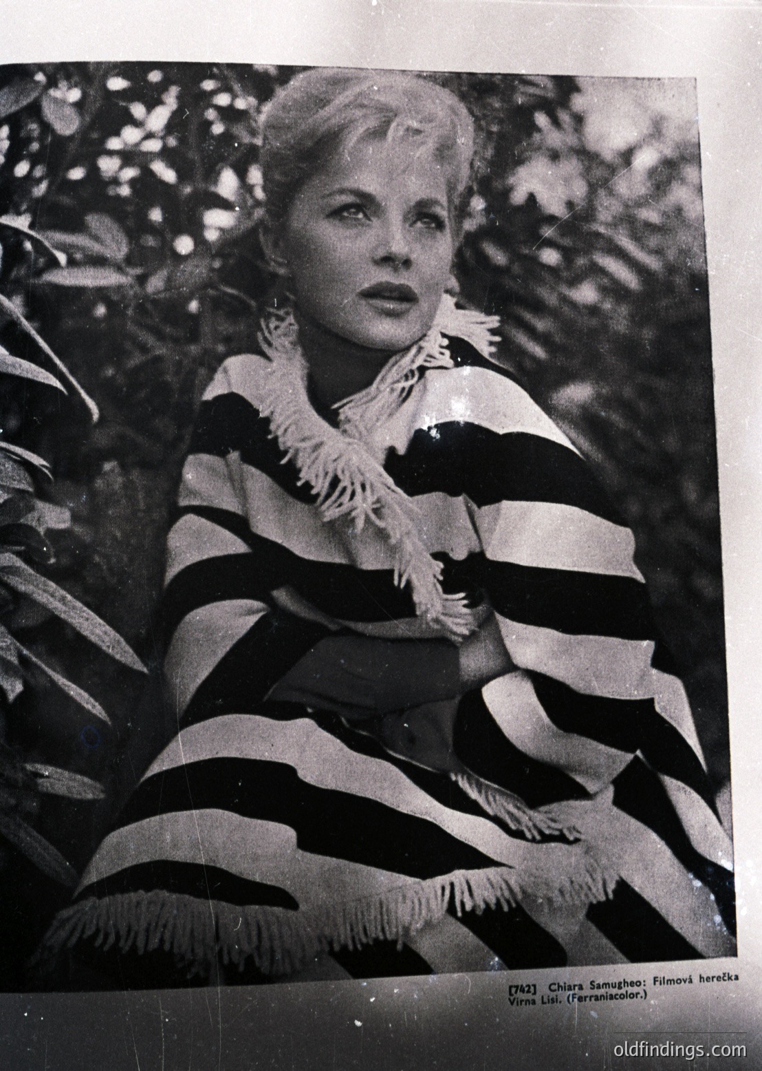 Vintage black-and-white portrait of a woman in a bold, striped sweater with a feathered collar, posed against a blurred greenery backdrop. Likely from Bulgaria’s 1960s–70s film industry (). Text suggests she’s Chavdar Samoilova, a notable actress ().