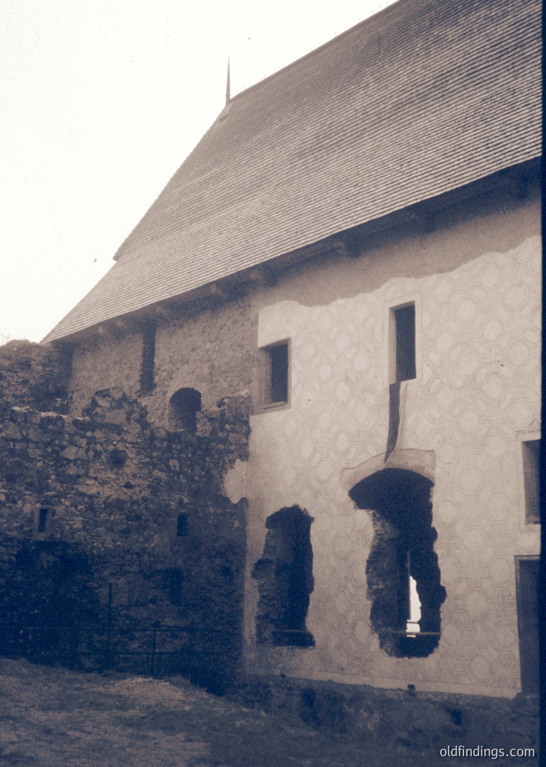 Historic stone-and-plaster building with exposed medieval archway remnants. Gabled roof and small rectangular window suggest European rural architecture. Likely or early century, possibly or .