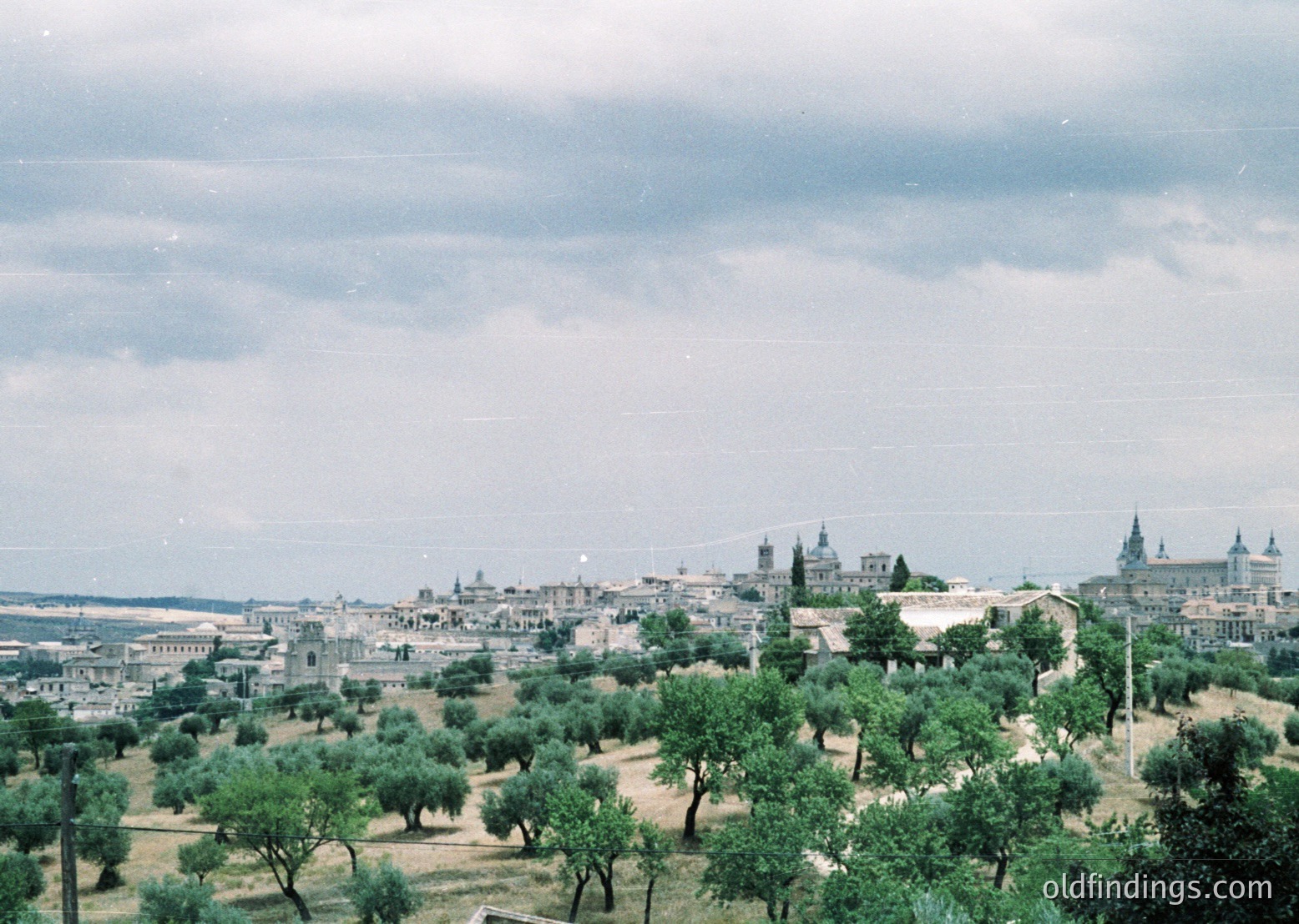 Vintage aerial view of Seville’s historic skyline, featuring olive groves in foreground and iconic cathedral spires (). Mid-20th century architecture with whitewashed buildings and lush greenery (). Ideal for historical research or Mediterranean design references ( ).