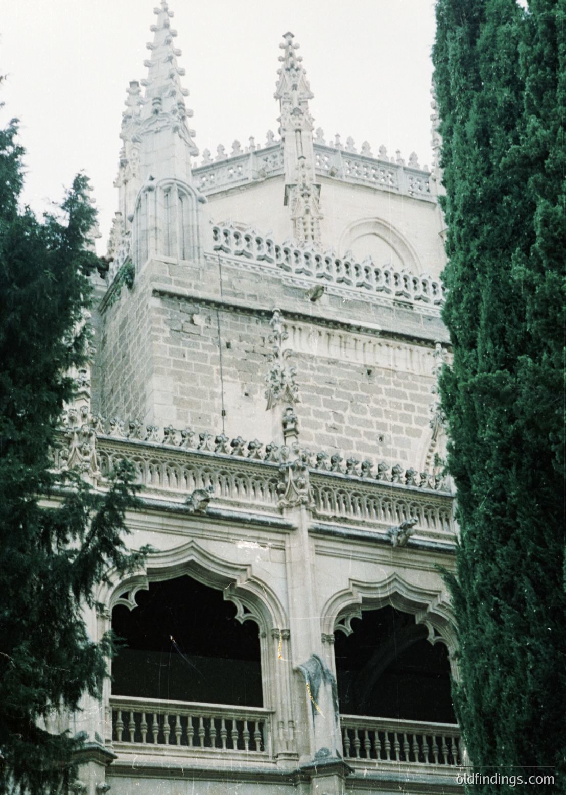Gothic Revival tower with ornate stonework, featuring pointed spires, arched balconies, and intricate carvings. Likely European, 19th-century architectural style.