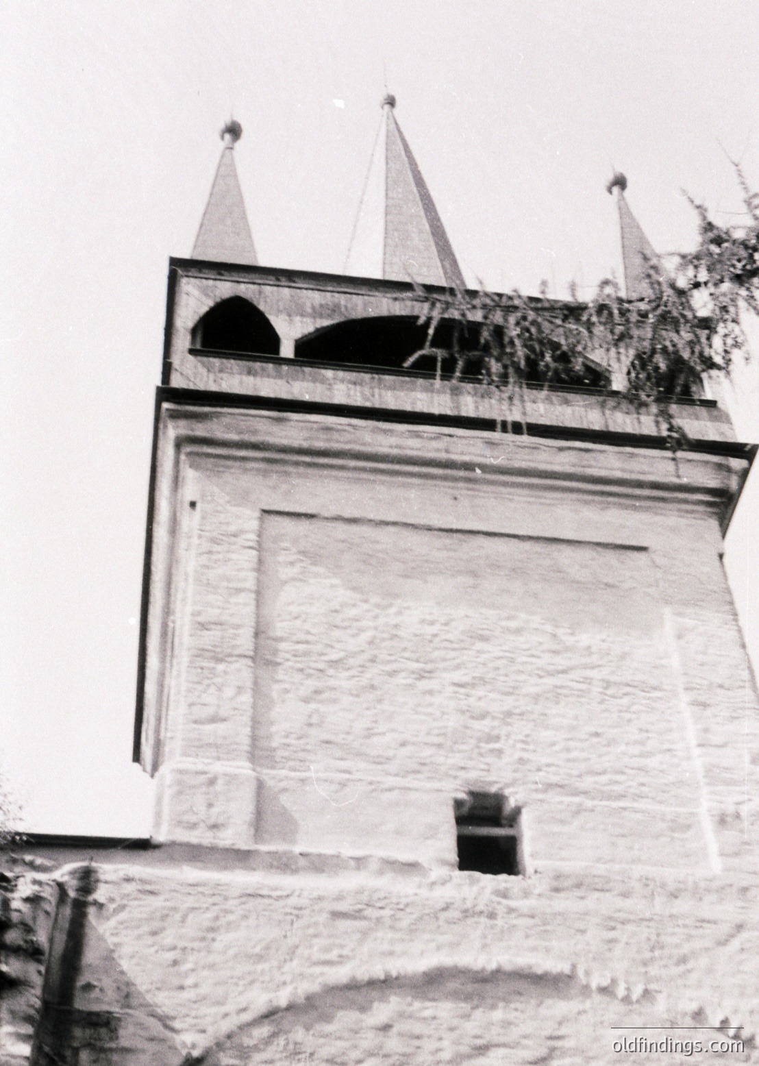 Historic stone tower with pointed conical roofs and arched ventilation openings, likely part of a fortress or monastery. Architectural style suggests Eastern European influence, possibly 19th-century. Weathered texture indicates age and exposure to elements.