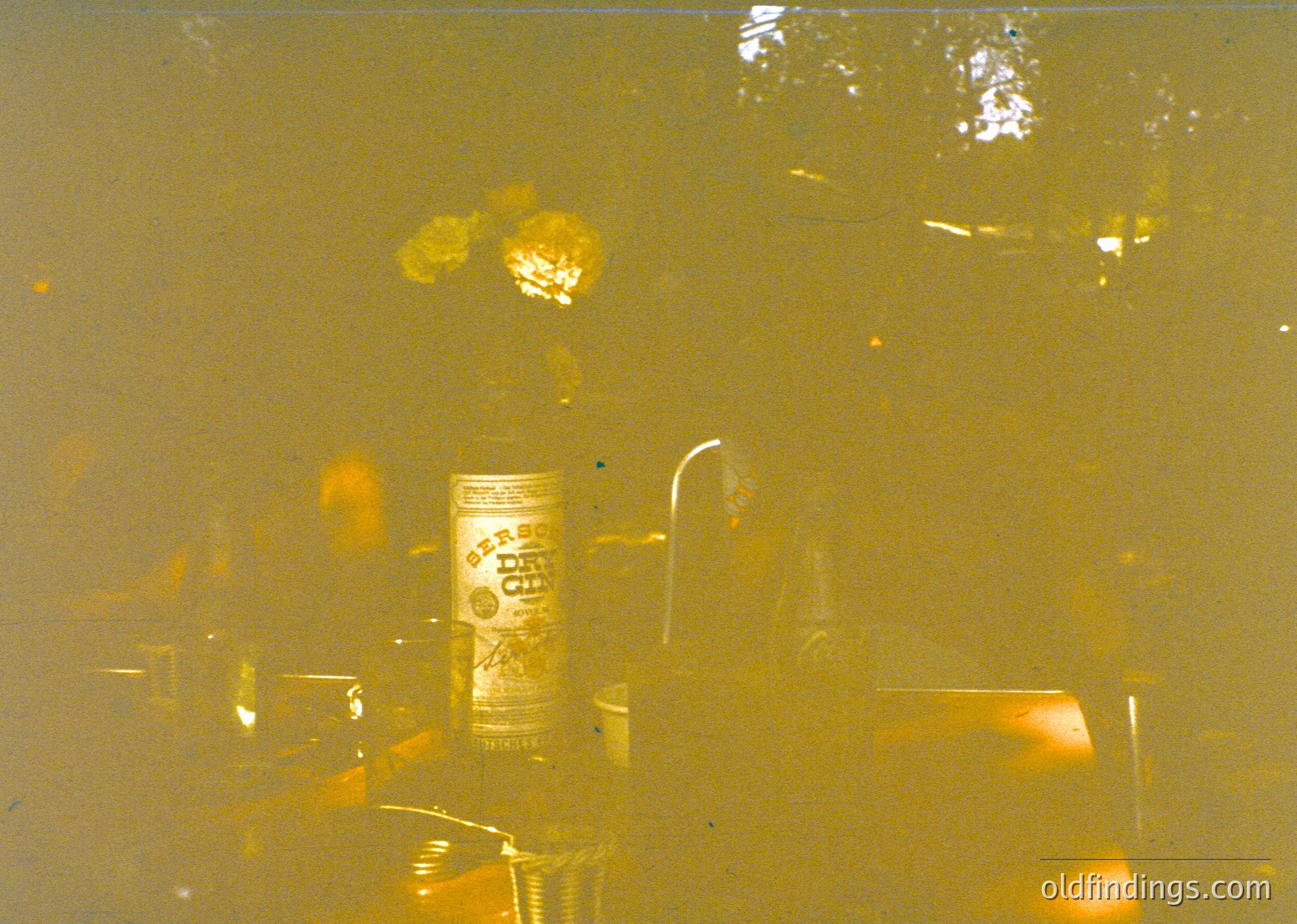 Vintage Polaroid-style shot of a beer can (Budweiser) on a reflective surface, blurred with warm sepia tones. Likely 1970s–1980s American casual setting. Ideal for nostalgic or retro-themed content.