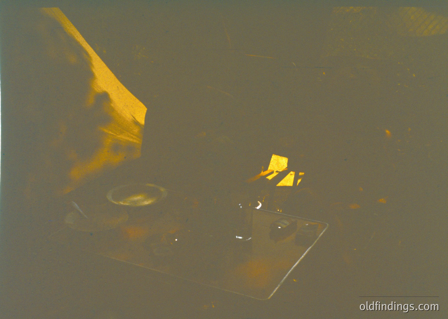 Vintage close-up of a retro electric stove with two burners, one lit with a yellow flame. The design suggests mid-20th century domestic kitchen tech.