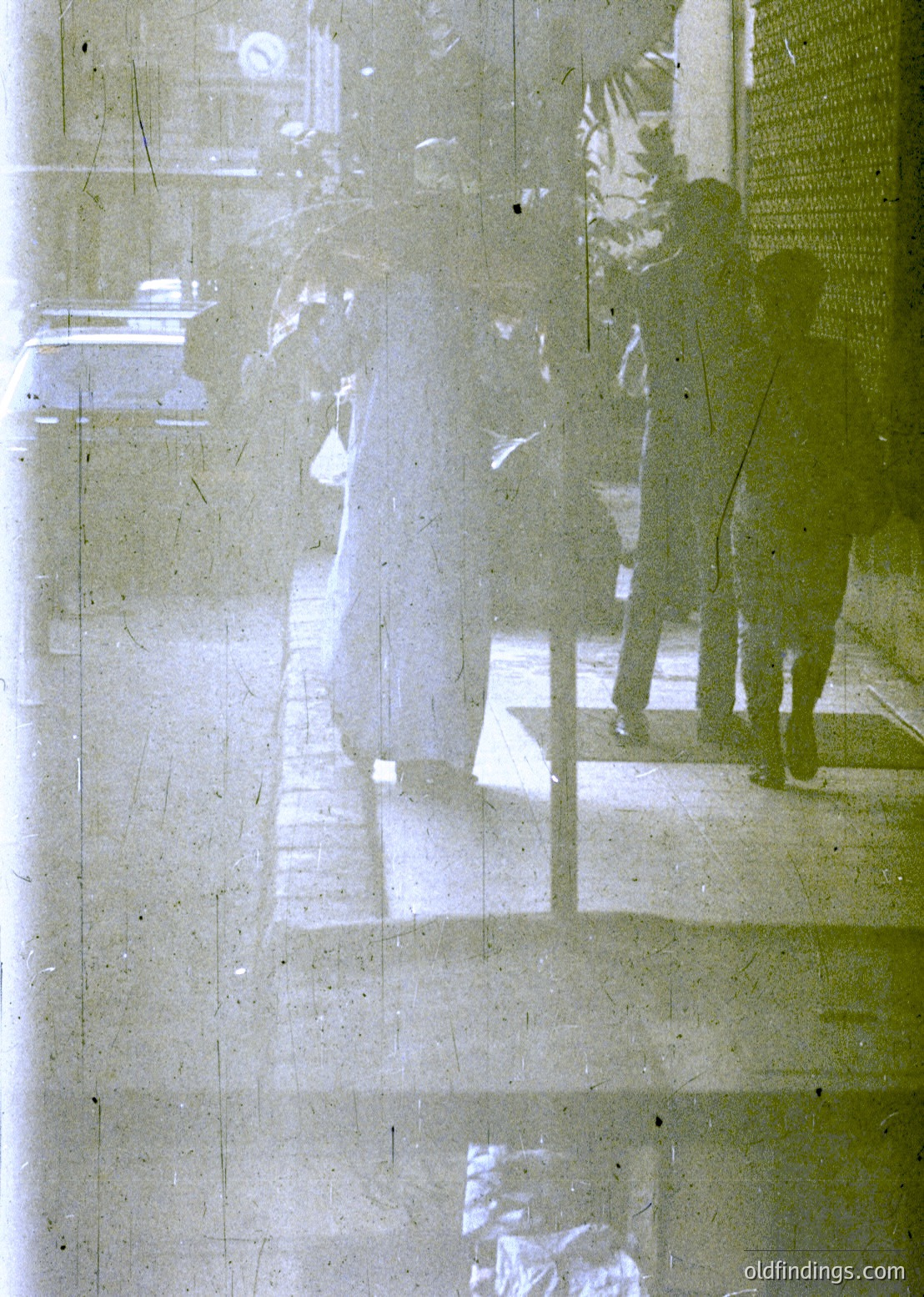Double-exposure urban reflection on glass, blending two distinct scenes: a shadowy figure ascending stairs and a blurred, light-filled interior with architectural details. Likely mid-20th century cityscape, possibly or .