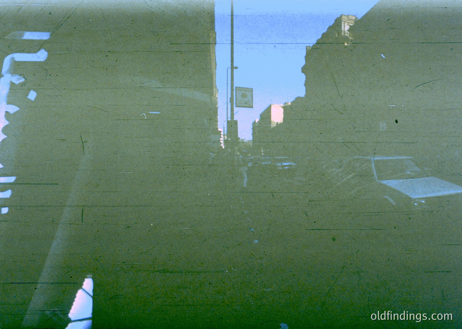 Vintage aerial view of urban infrastructure, likely a highway or overpass, with visible concrete barriers and road markings. The faded color suggests a 1970s–1990s timeframe. Reflections hint at nearby water or a reflective surface.