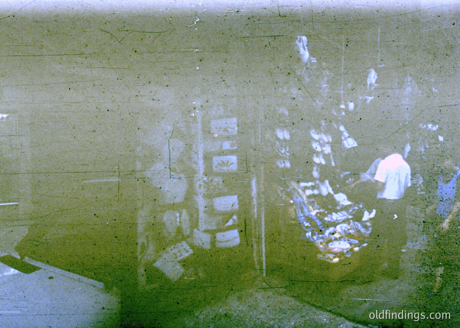 Vintage aerial view of a densely built urban area with grid-like streets and low-rise buildings, likely from the 1950s–1970s. Reflections and film grain suggest a low-angle or tilted camera shot. Urban planning and residential density evident.