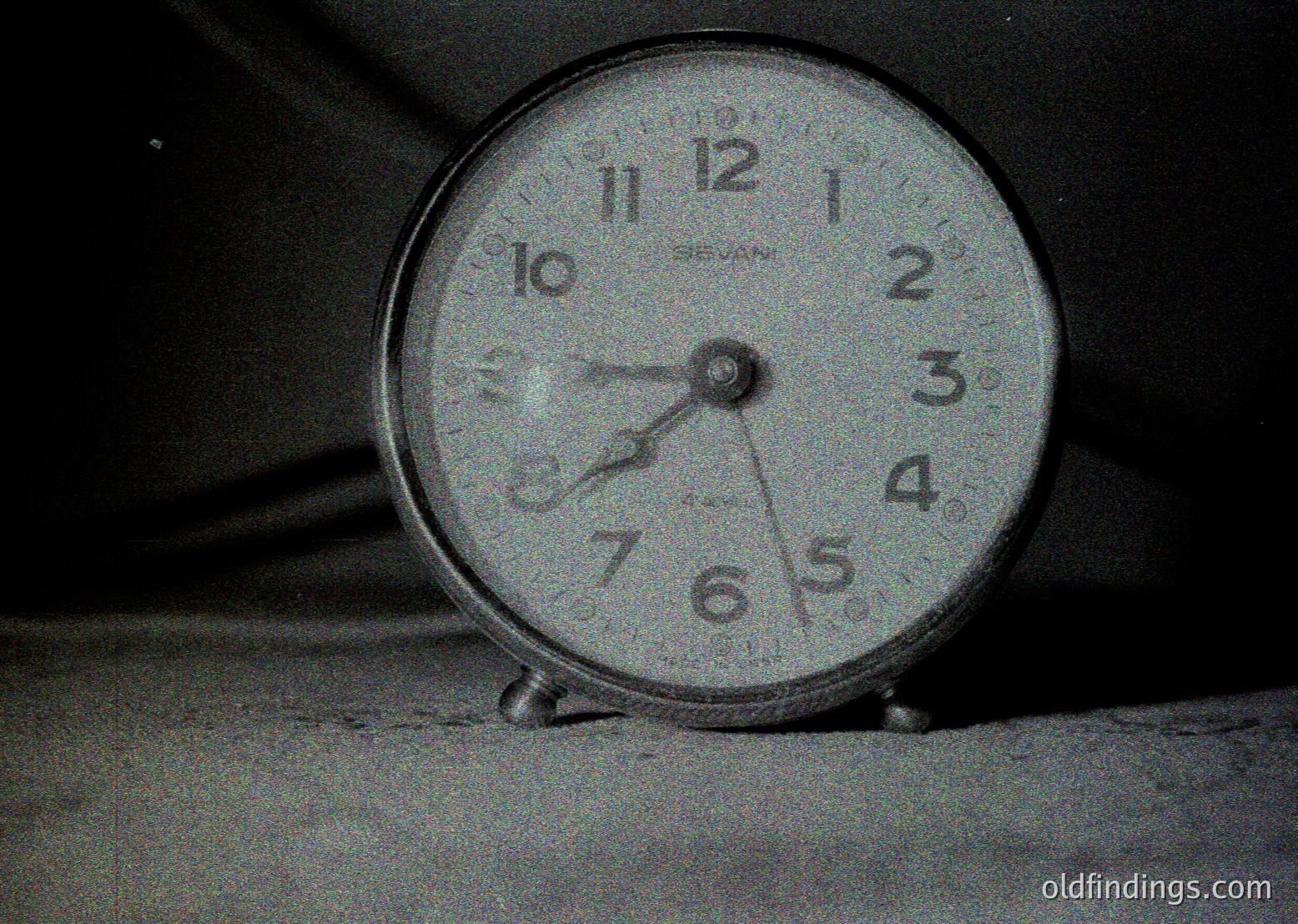 Vintage analog alarm clock with rounded edges, displaying 10:10. Marked "BEYAN" on the face, likely mid-20th century. Simple, utilitarian design with a dark base and light dial.