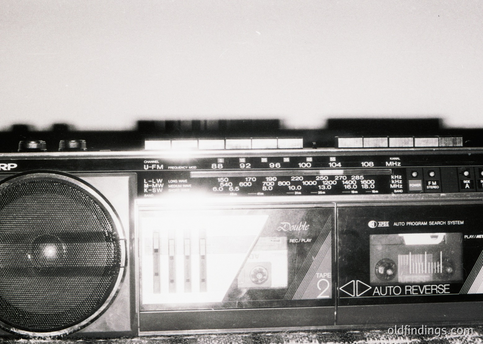 Vintage double-cassette boombox with "Double" and "Auto Reverse" labels, featuring analog tuning dials and a graphic equalizer display. Likely mid-20th century (1970s-1980s) portable audio tech.