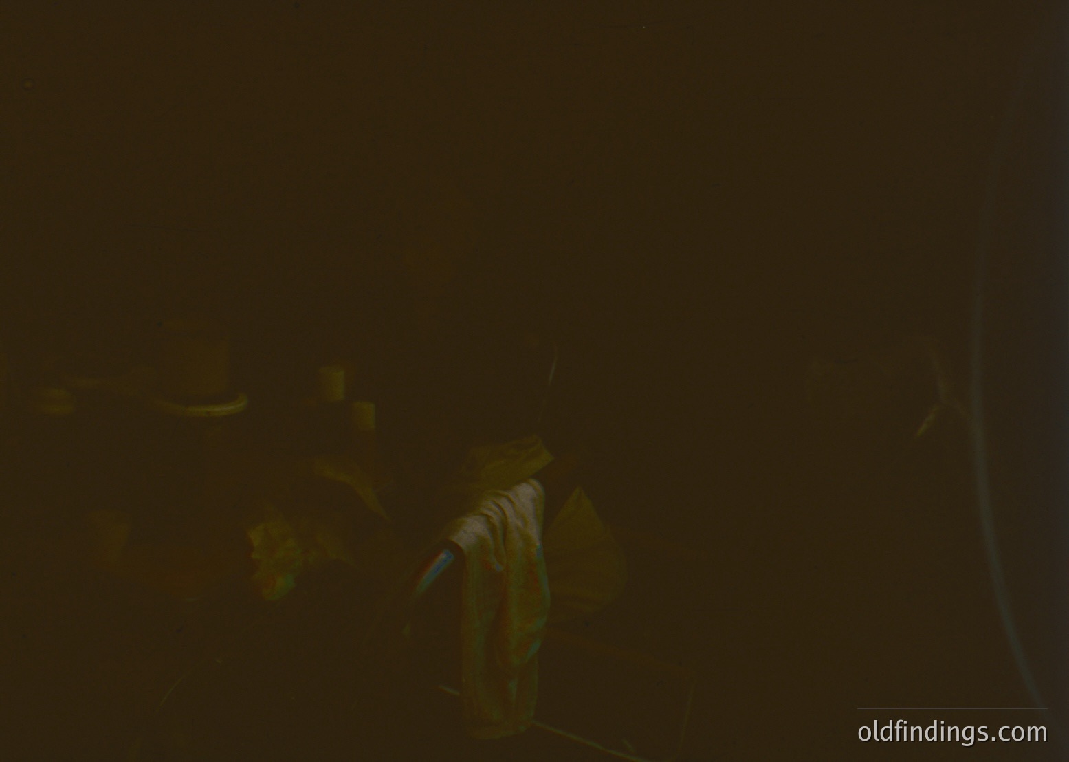 Vague low-light shot of a person holding a cigarette in an indoor setting, likely a bar or lounge. Blurred details obscure facial features and surroundings. Style suggests mid-20th century ambiance.