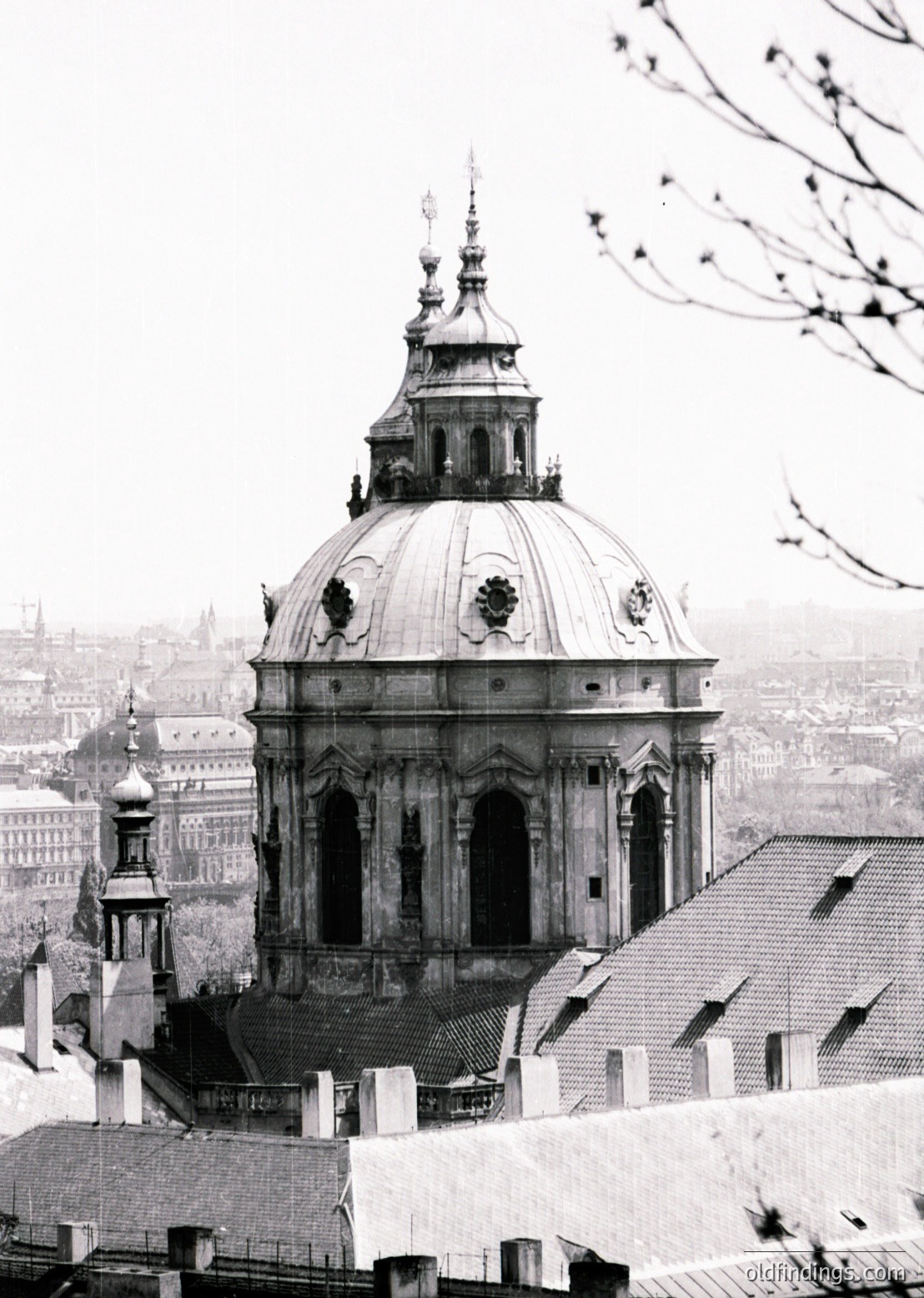 Baroque-style dome with ornate copper roofing and decorative finials, likely part of St. Stephen’s Basilica, Budapest. Urban rooftops and distant cityscape visible below. Black-and-white vintage photograph, c. late 19th–early 20th century.