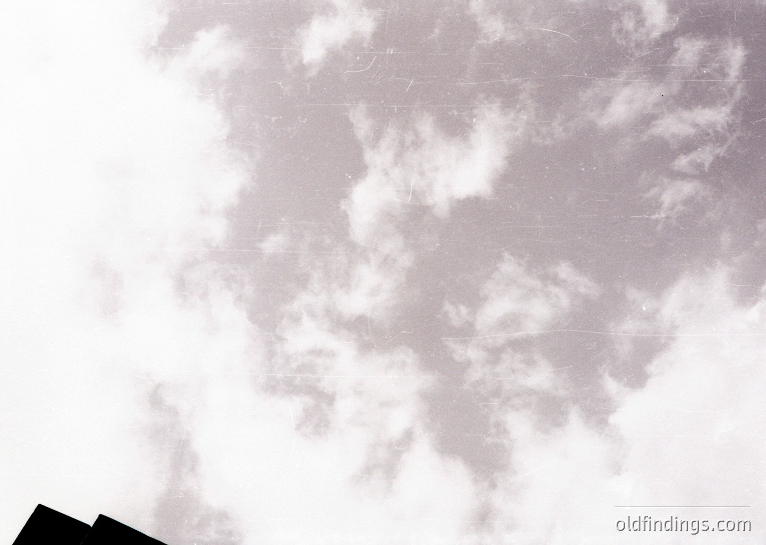 Vintage sepia-toned aerial photograph showing cloud patterns over an indistinct terrain, likely from early 20th-century aviation. Low resolution reveals no clear landmarks but suggests historical aviation or meteorological study.