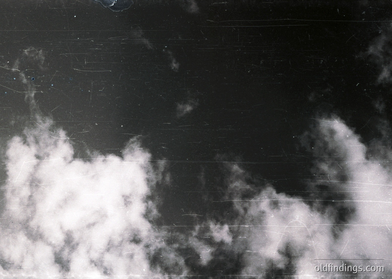 High-contrast black-and-white sky with dense, textured clouds against a dark, slightly scratched surface. Dramatic lighting emphasizes cloud formations and subtle atmospheric haze. Ideal for moody, cinematic, or abstract visuals.