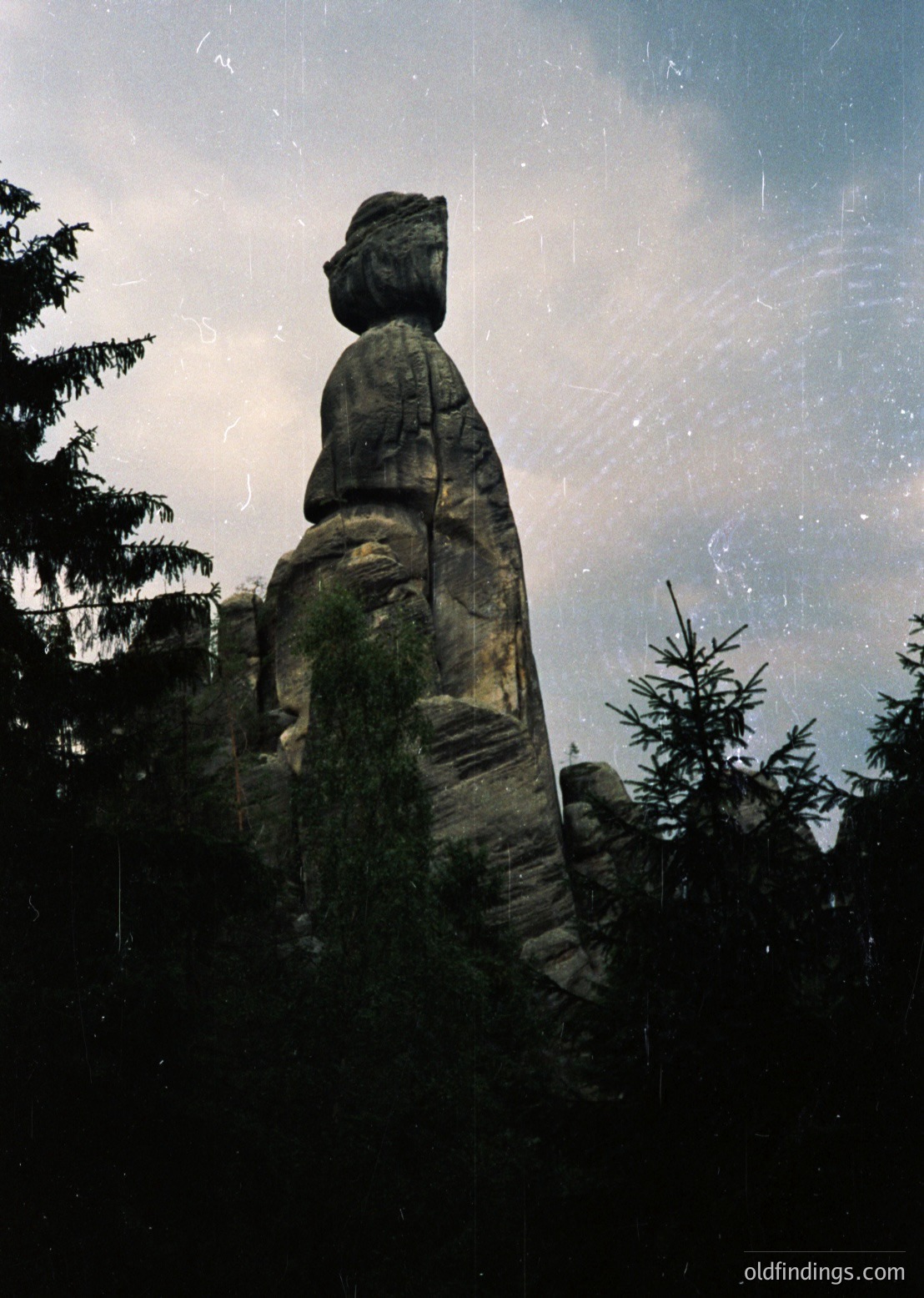 Carved sandstone rock formation resembling a seated human figure in a forested landscape. Likely part of the **Rügnitz Rocks (Rügen Island, Germany)**—iconic natural sculptures. ügenIsland