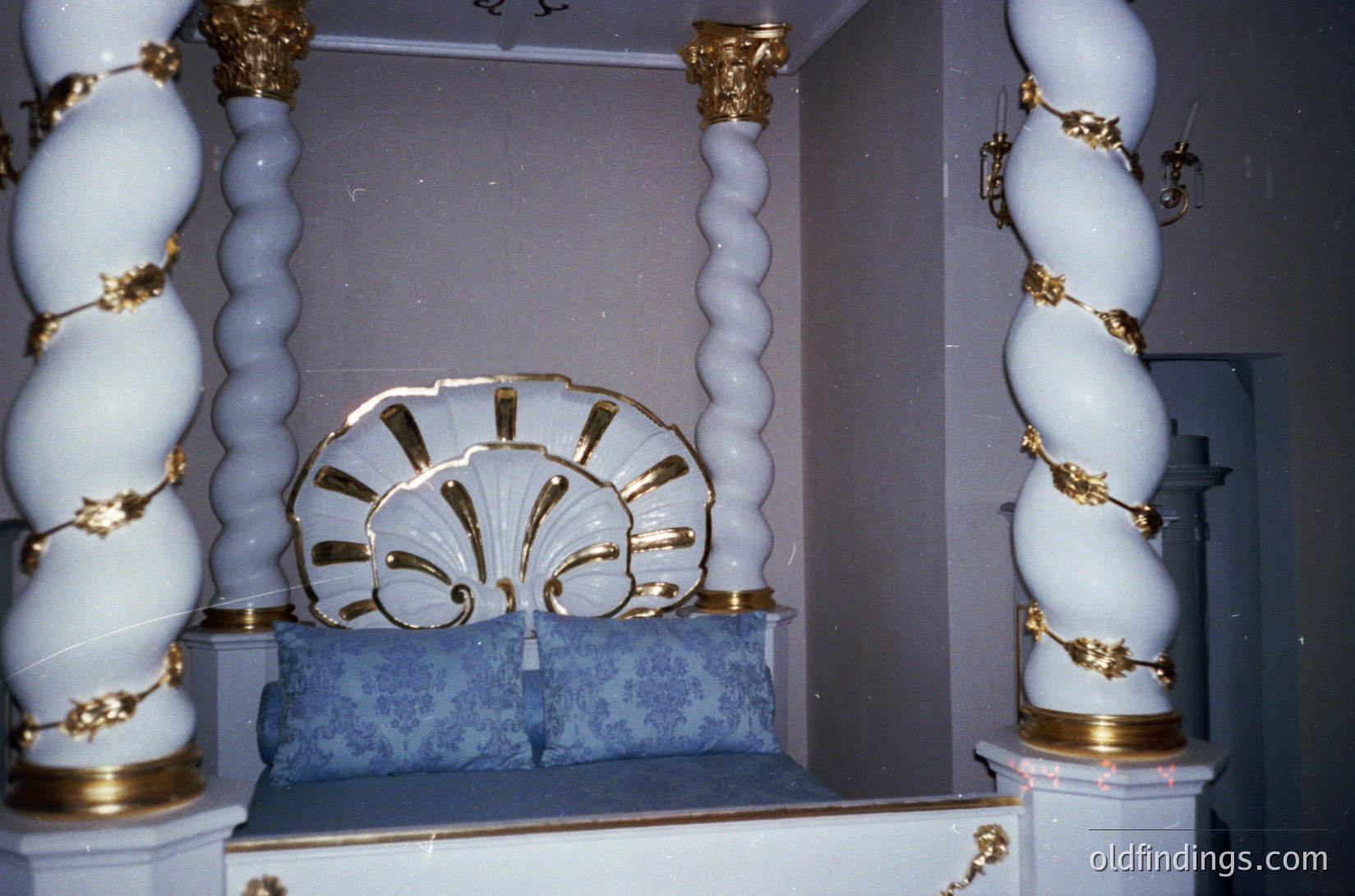 Elaborate synagogue interior featuring ornate **Ark (Aron Kodesh)** with gold-accented white marble columns and a scalloped shell motif. Intricate floral and geometric patterns in gold detail the base and upper arches. Likely Eastern European or Sephardic design, indicative of early-to-mid 20th-century synagogue architecture.