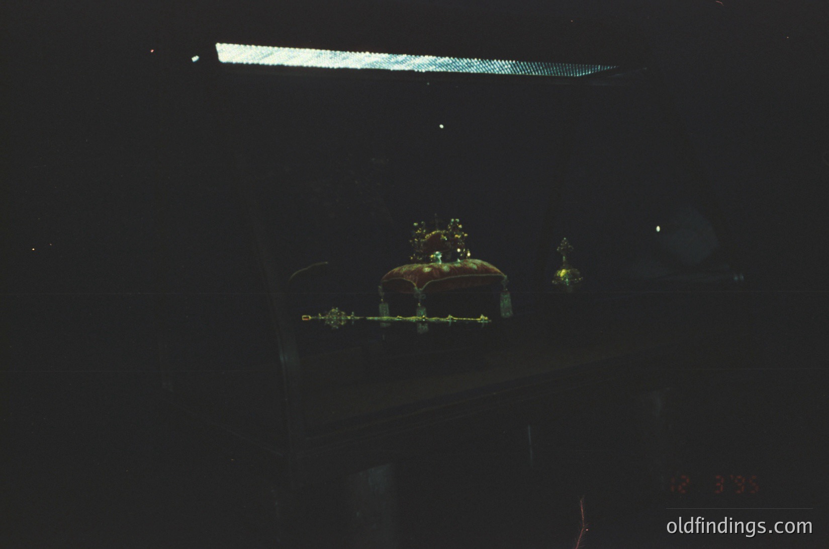 Low-light shot of a **retro analog audio cassette** in a dark case, illuminated by faint green/yellow light. Reflections and grainy texture suggest vintage photography. Ideal for **nostalgic media, tech history, or sound design references**.