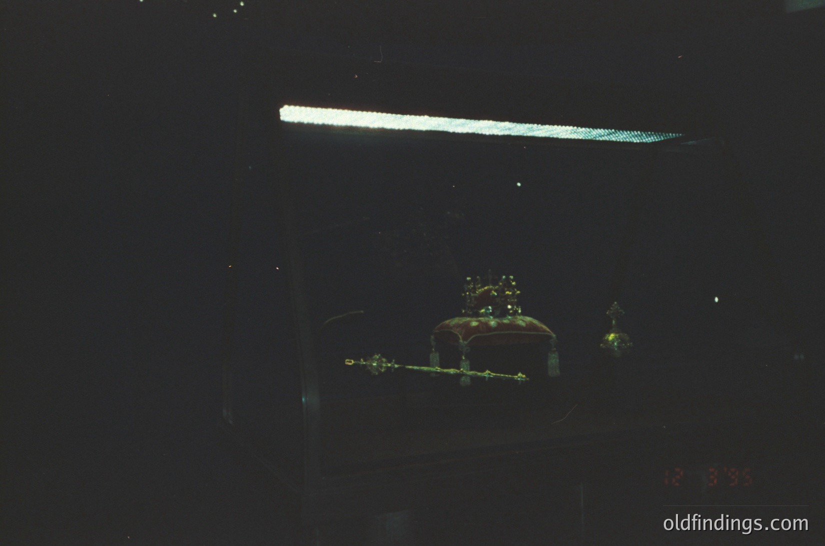 Vintage neon sign featuring a crown and ornate letters, likely "Crown" or "Crown Inn." Glowing amber-yellow against dark background, suggesting 1950s–1970s motel or diner aesthetic. Reflections and lens flare add nostalgic depth.