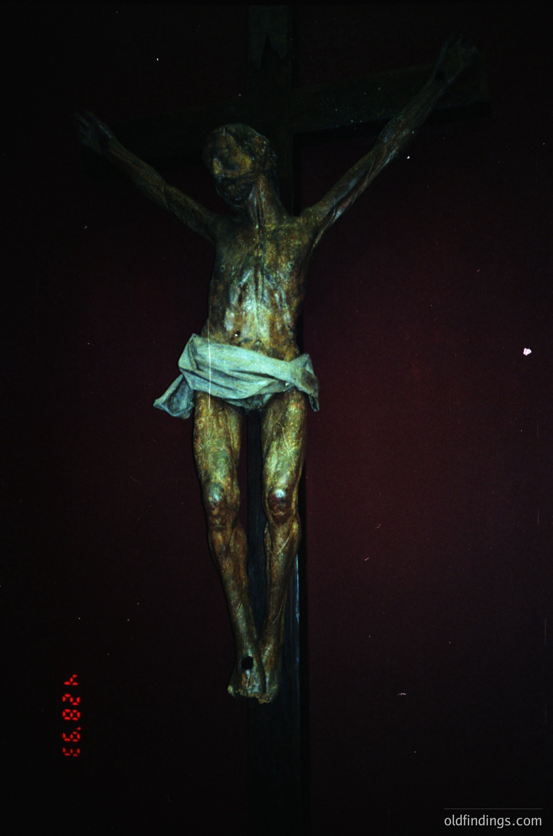 Bronze crucifix sculpture depicting Christ on the cross, draped in a minimalist white cloth. Patinated surface shows age and craftsmanship. Likely 19th–20th century European religious art. Ideal for historical research or ecclesiastical design references.