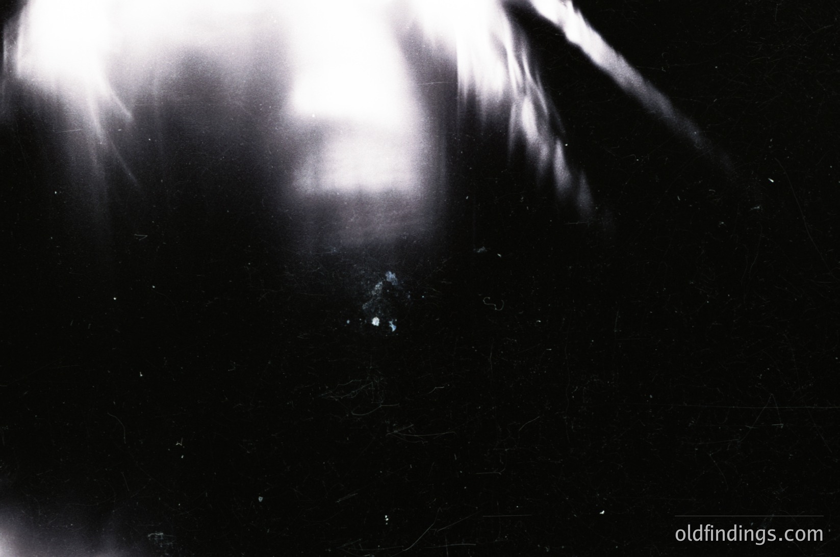 High-contrast black-and-white portrait with dramatic lighting, capturing a close-up of a person’s face obscured by strong backlighting and lens flare. The silhouette suggests a mid-20th-century photographic style, likely 1950s–1970s. Ideal for moody, artistic stock or historical research on portraiture techniques.