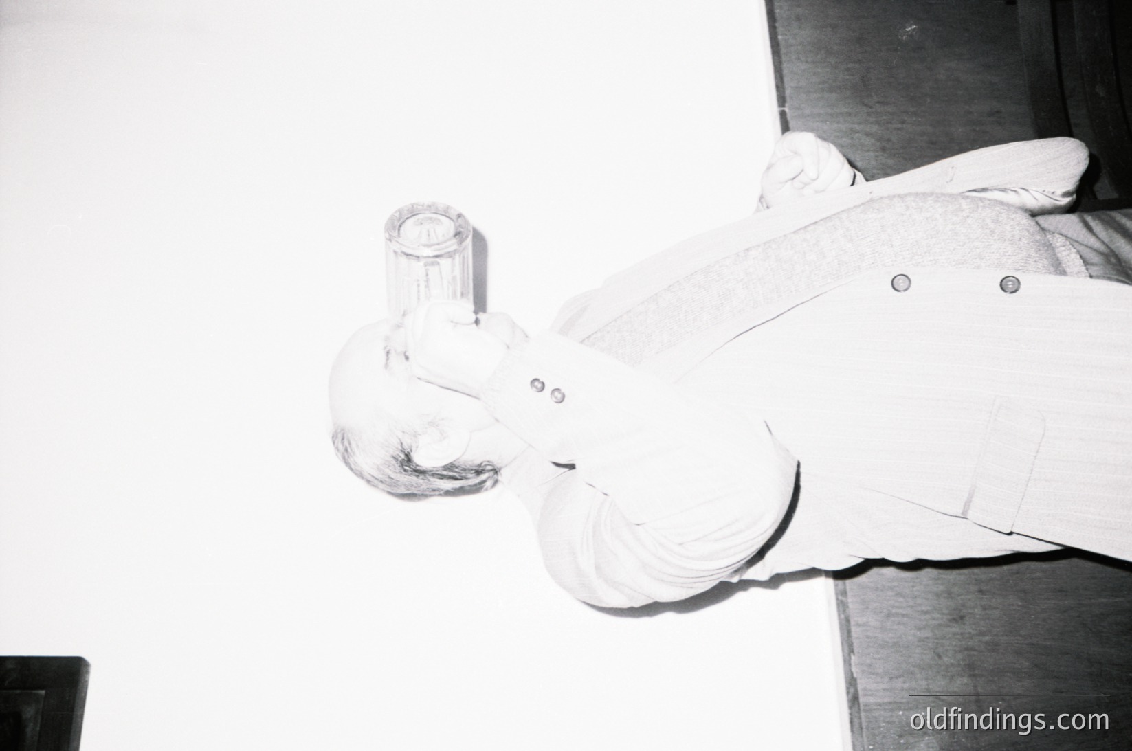 Close-up of a vintage glass ashtray shaped like a curled cigarette, featuring a hollowed-out design for ash collection. The smooth, frosted glass and riveted metal base suggest mid-20th century industrial design. Ideal for retro-themed interiors or vintage decor.