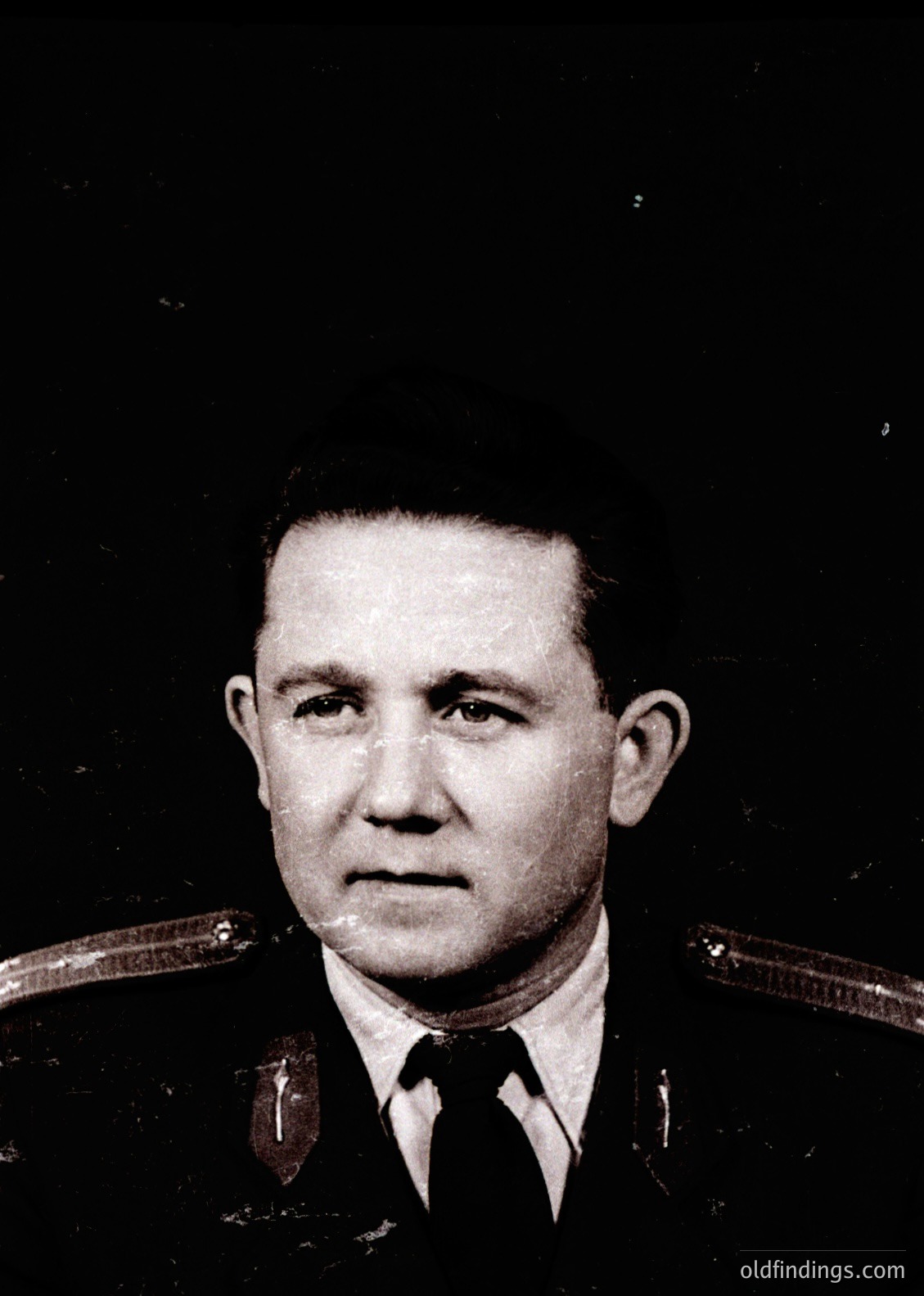 Portrait of a man in a Soviet-era military uniform, featuring shoulder boards with star insignia and a dark tie. The formal pose and uniform suggest an official or military context, likely from the mid-20th century (1940s–1980s). The black-and-white tone and styling align with Cold War-era photography.