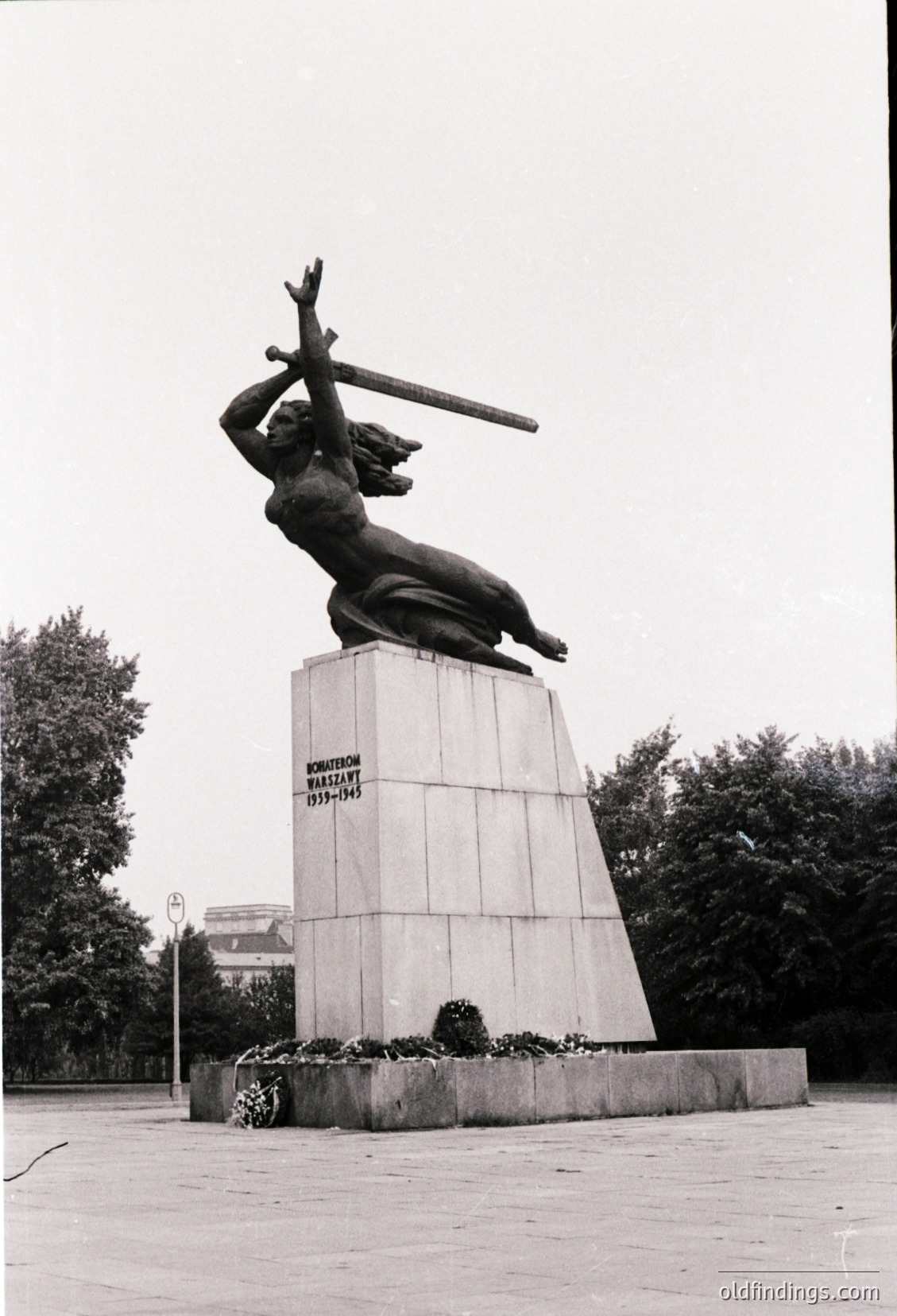 Bronze statue of a woman holding a sword aloft on a rectangular pedestal, commemorating "Kirovohrad 1939–1945." Mid-20th century Soviet-era monument in an urban park setting.