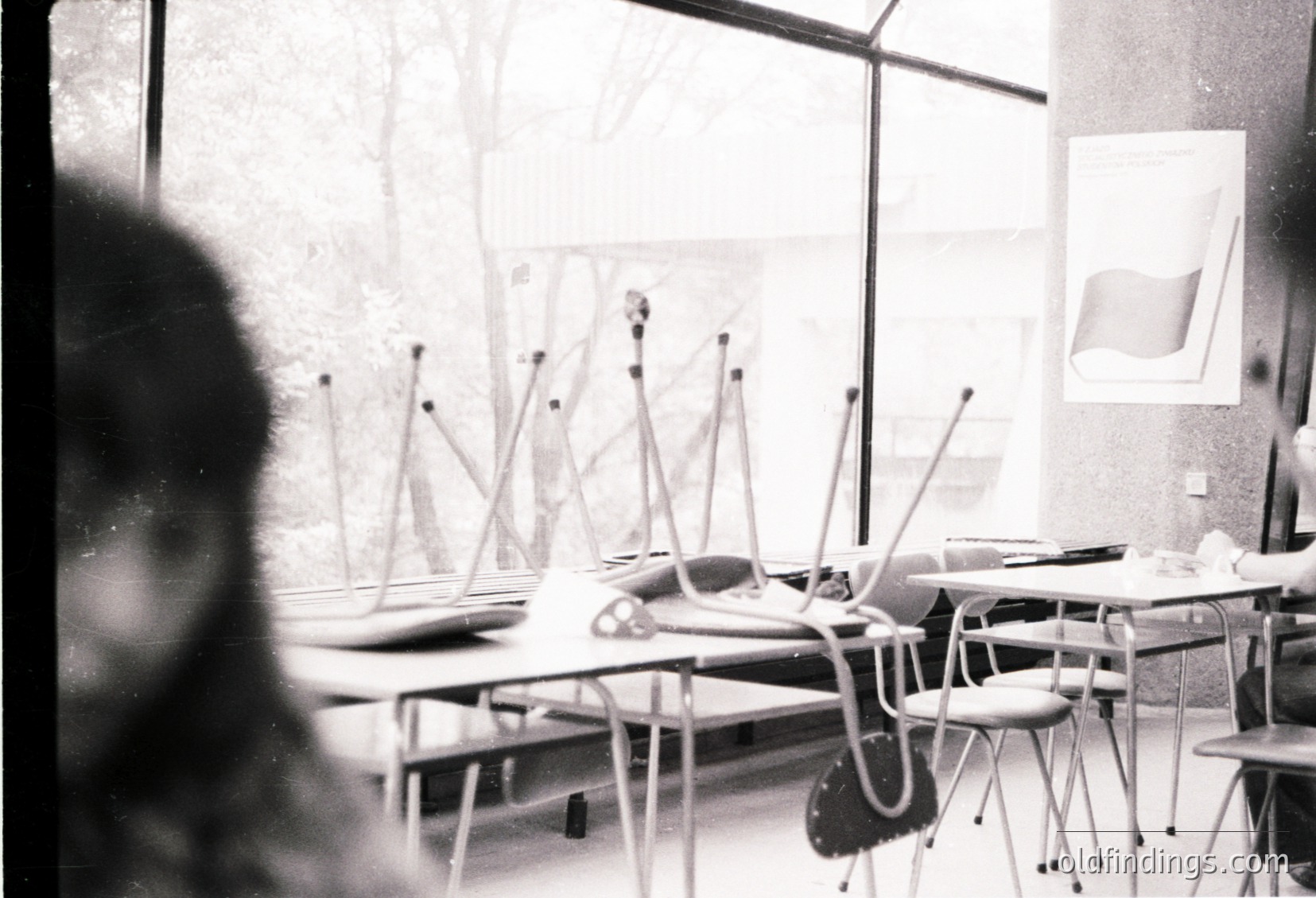 Mid-century classroom with tiered desks and chairs, likely –. Overhead projector and chalkboard setup suggests educational focus. Minimalist, functional design reflects post-war educational reform. Potential for historical research or vintage design references.