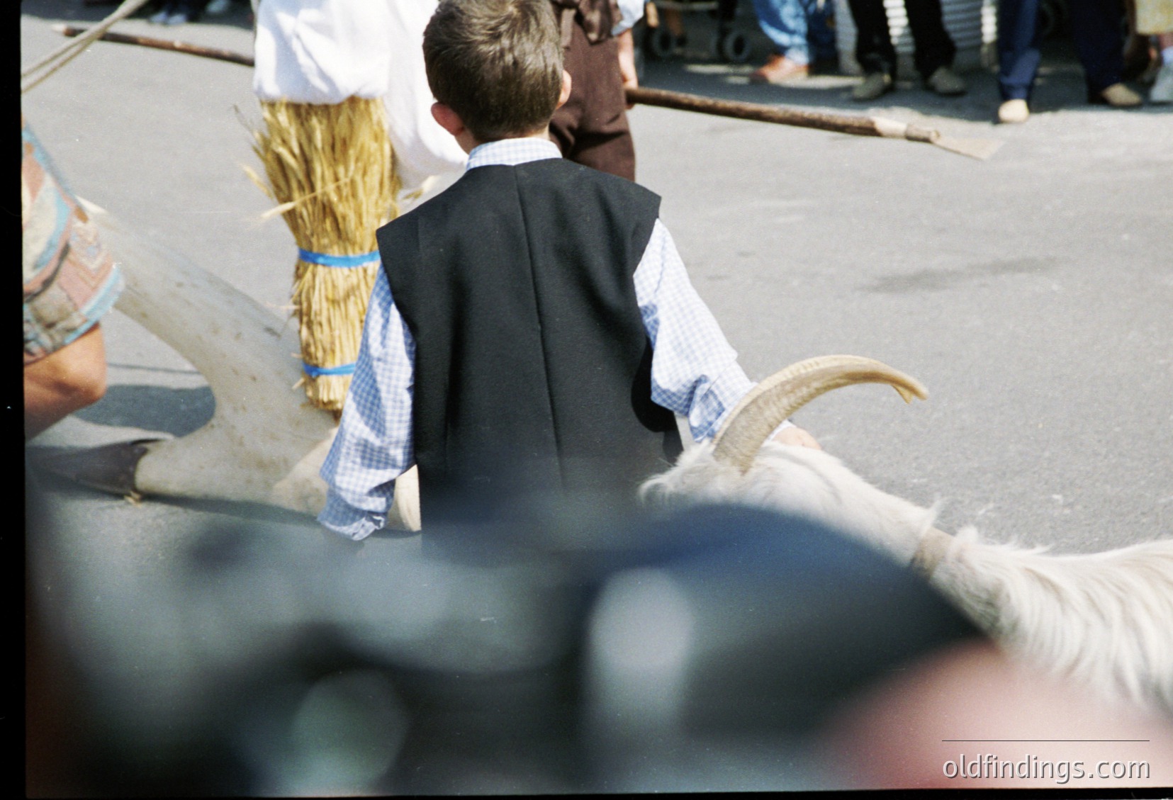 Traditional alpine festival scene: men in handcrafted wool costumes with antler headpieces and checkered aprons. Crowd in background suggests communal celebration. Likely *(Note: Exact location/time speculative; alpine regions like Austria/Tyrol are common for such festivals.)*